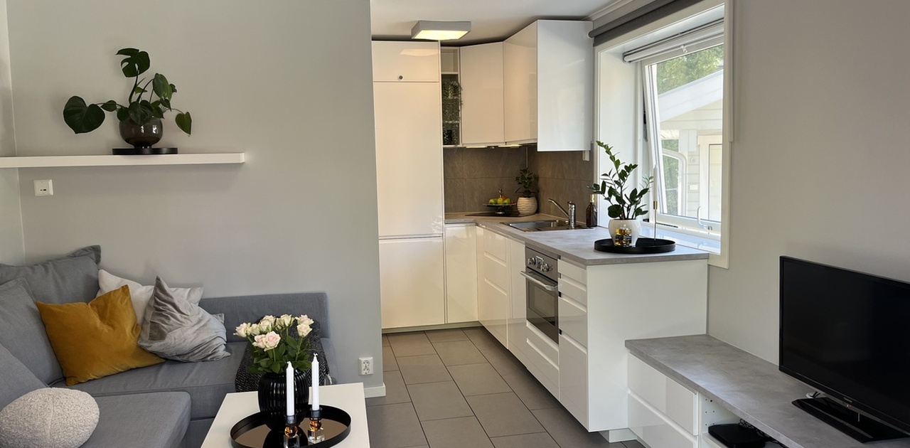 Lys og moderne stue med kjøkkenløsning